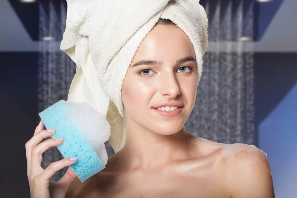 Girl in shower holding wisp with foam — Stockfoto
