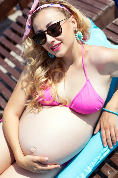 Pregnant woman is lying on sunbed — Stock Photo, Image