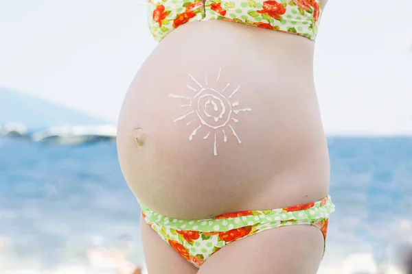 Loción protector solar en el vientre embarazada — Foto de Stock