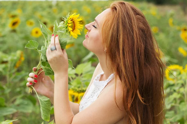 Gelukkige vrouw in het veld met zonnebloemen — Stockfoto