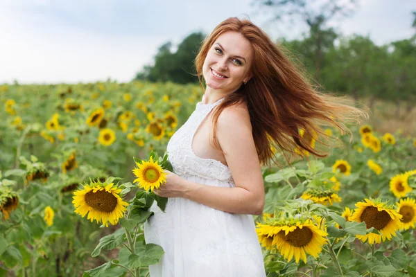 Těhotná dívka v poli s slunečnice — Stock fotografie