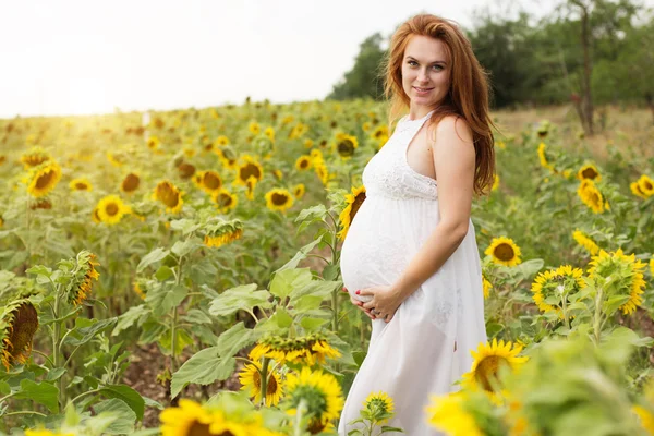 Pregnant fashion girl in sunflowers field — Stock Photo, Image