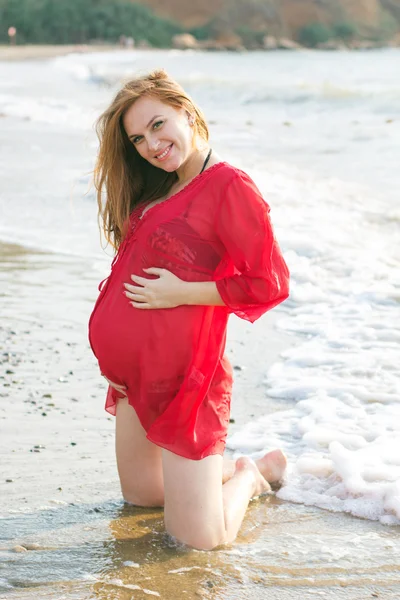 Zwangere vrouw aan het zandstrand — Stockfoto