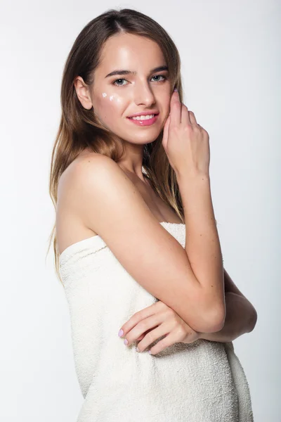 Girl in towel after shower with moisturizing cream — Stockfoto