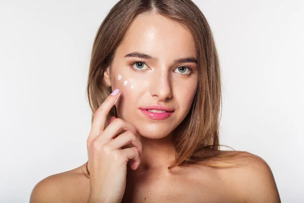 Menina na toalha após o chuveiro com creme no rosto — Fotografia de Stock