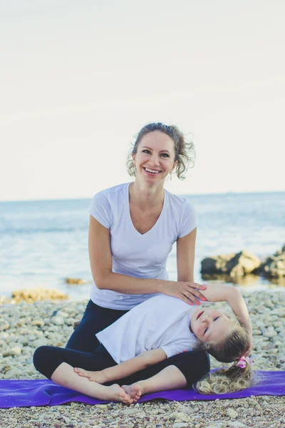 Madre e hija haciendo yoga al aire libre —  Fotos de Stock