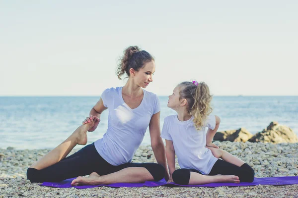 Madre e hija haciendo yoga al aire libre —  Fotos de Stock