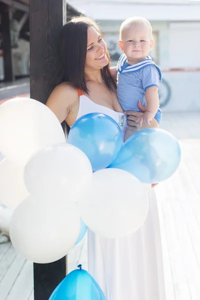 Mãe e filho pequeno com balões ao ar livre — Fotografia de Stock
