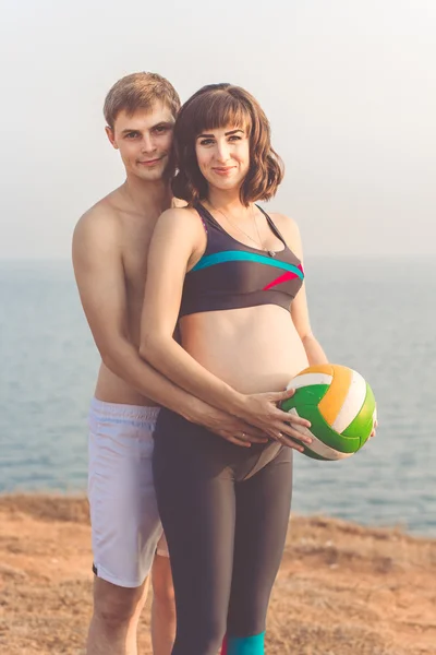 Спортивная пара мужчина и его беременная жена — стоковое фото