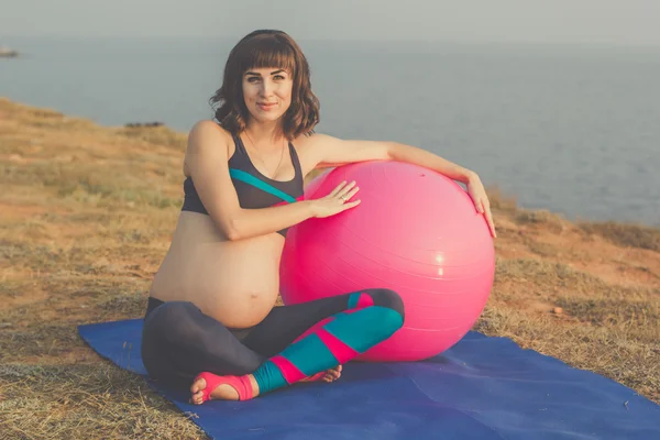 Pregnant girl with pink fitball — Stock Photo, Image