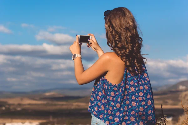 Pretty teen flicka att ta foto av naturen via telefon — Stockfoto