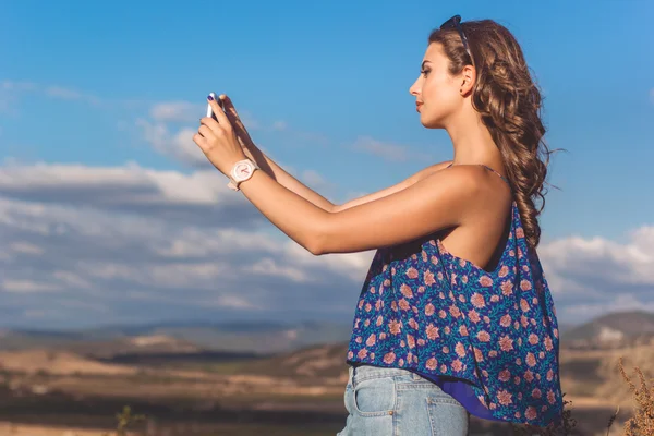 Pretty teen flicka att ta foto av naturen via telefon — Stockfoto