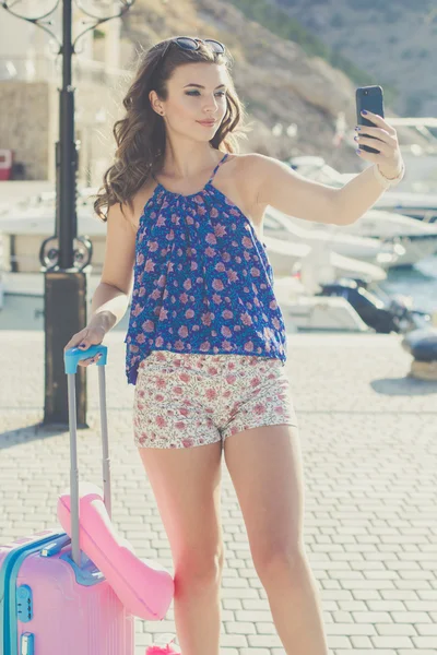 Pretty girl with pink suitcase taking selfie — Stock Photo, Image