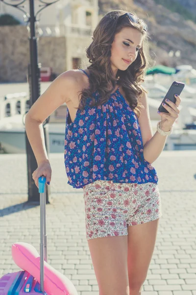 Vackra traveler tjej med rosa resväska och mobiltelefon — Stockfoto