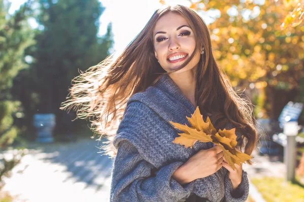 Pretty woman in park with autumn yellow leaves — Stock Photo, Image