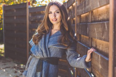 Kız yakınındaki ahşap duvar örme giysiler giyiyor