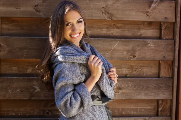 Ragazza indossa vestiti a maglia vicino muro di legno — Foto Stock