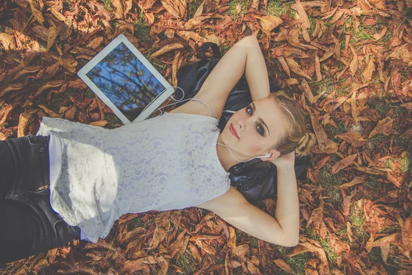 Menina adolescente com tablet digital no outono ao ar livre — Fotografia de Stock