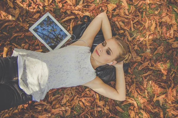 Menina adolescente com tablet digital no parque de outono — Fotografia de Stock