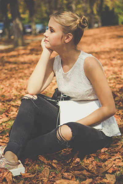 Chica está sentado con la tableta digital al aire libre —  Fotos de Stock