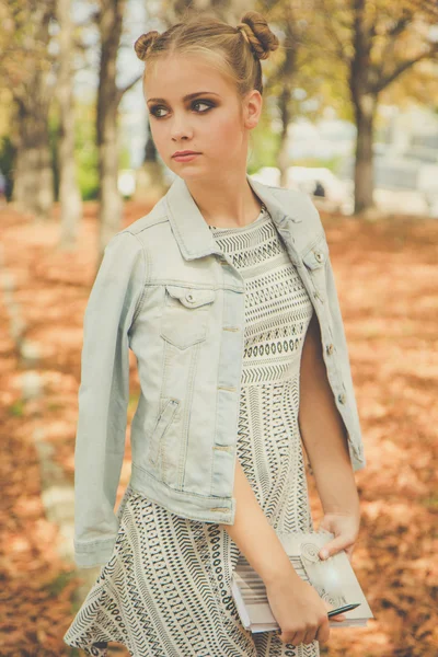 Sad teen girl in autumn park with notebook — Stock Photo, Image