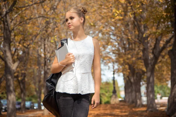 Дівчина з цифровим планшетом в осінньому парку — стокове фото