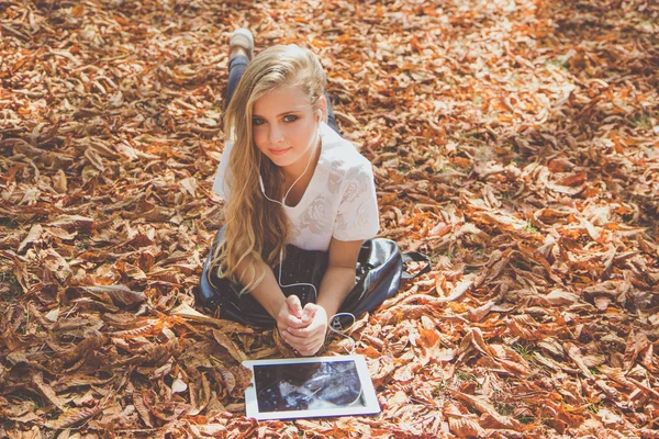 Ragazza adolescente nel parco autunnale con pc — Foto Stock