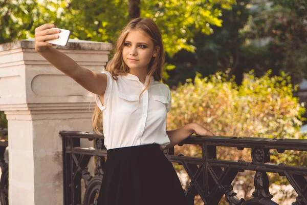 Teen dziewczyna w parku jesień jest biorąc selfie — Zdjęcie stockowe