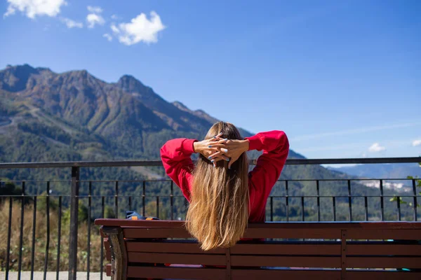 若い女性は背景に山の景色とソチのベンチに座っています,ロシア. — ストック写真