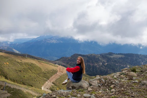 若い女性はソチの山の崖の上に座っている、ロシア. — ストック写真