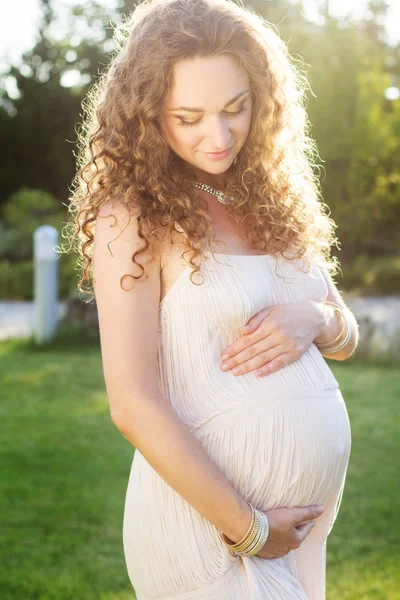 Beautiful pregnant woman relaxing in the park Stock Photo