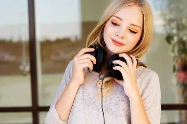 Jovem adolescente feliz está usando fones de ouvido — Fotografia de Stock