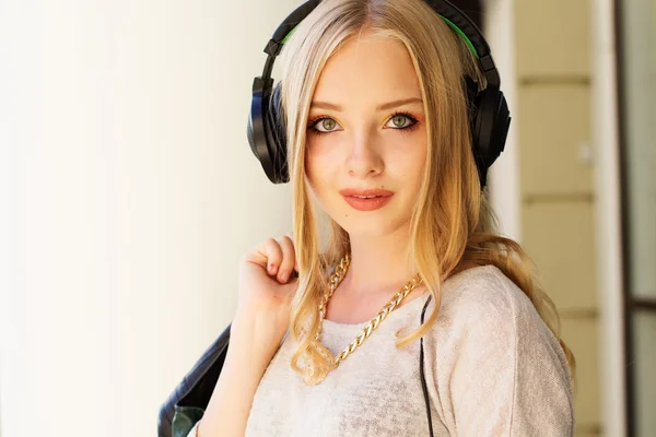 Jovem adolescente feliz está usando fones de ouvido — Fotografia de Stock