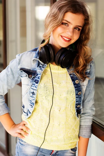 Joven adolescente feliz está usando auriculares — Foto de Stock