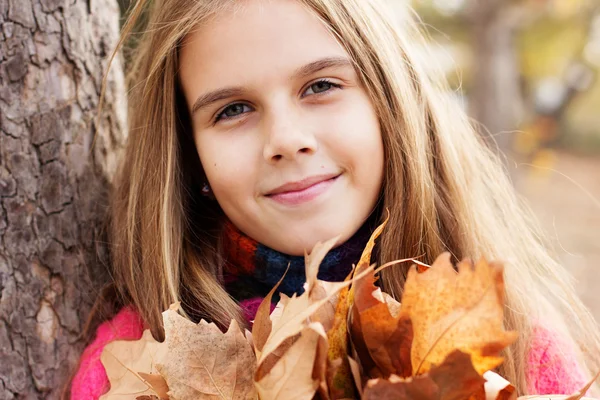 Happy child girl with fallen golden leaves — Stock Photo, Image
