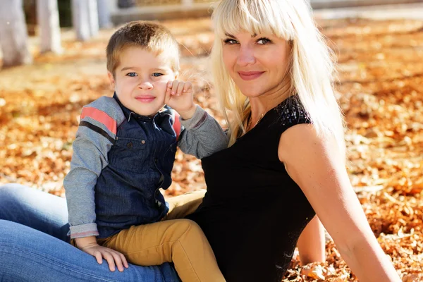 Маленький мальчик в осеннем парке со своей матерью — стоковое фото