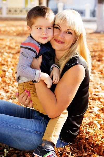 Little toddler boy in autumn park with his mother — Stock Photo, Image