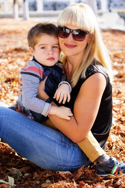 Little toddler boy in autumn park with his mother — Stock Photo, Image