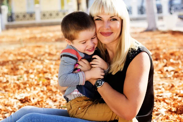 Little toddler boy in autumn park with his mother — Stock Photo, Image