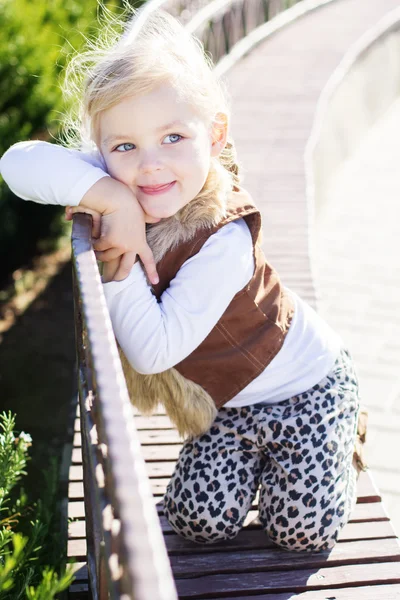 La niña está sentada en el banco, en otoño. —  Fotos de Stock