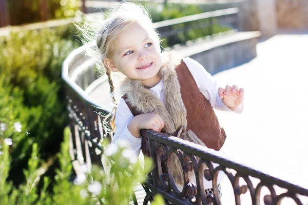 La niña está sentada en el banco, en otoño. —  Fotos de Stock