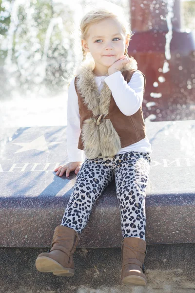 Маленька дівчинка біля фонтану, осінь — стокове фото