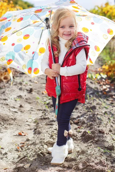 Holčička s deštníkem v červené vestě venkovní — Stock fotografie