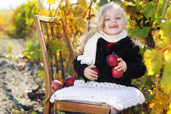 Rozkošná holčička s jablky, podzimní čas — Stock fotografie