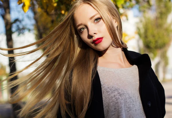 Bella ragazza con i capelli volanti in foglie colorate — Foto Stock