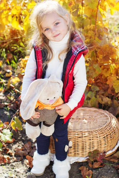 Little girl in warm clothes with toy rabbit — Stock Photo, Image