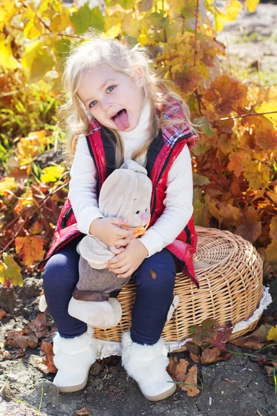 Little girl in warm clothes with toy rabbit — Stock Photo, Image