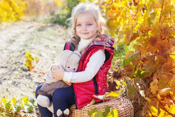 Kleines Mädchen in warmer Kleidung mit Spielzeugkaninchen — Stockfoto