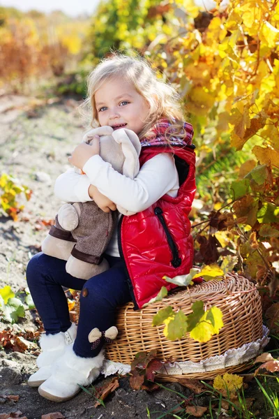 Sıcak elbiseleri oyuncak tavşan ile küçük kız — Stok fotoğraf