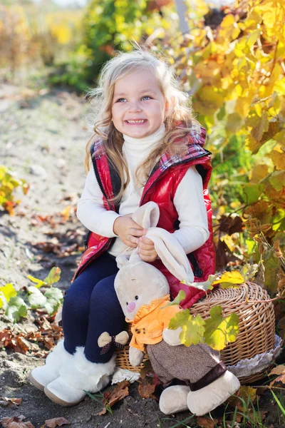 Маленькая девочка в теплой одежде с игрушечным кроликом — стоковое фото